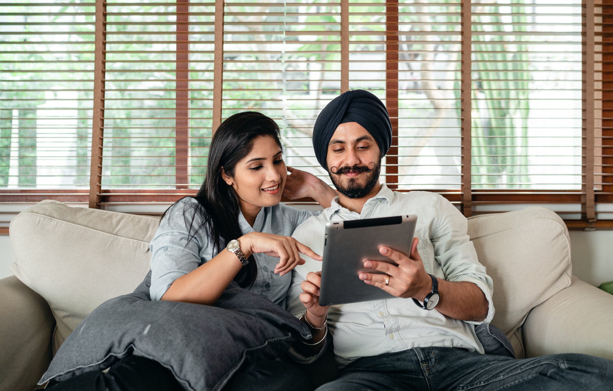 A loving couple browsing online to learn more about the concept of open adoption.