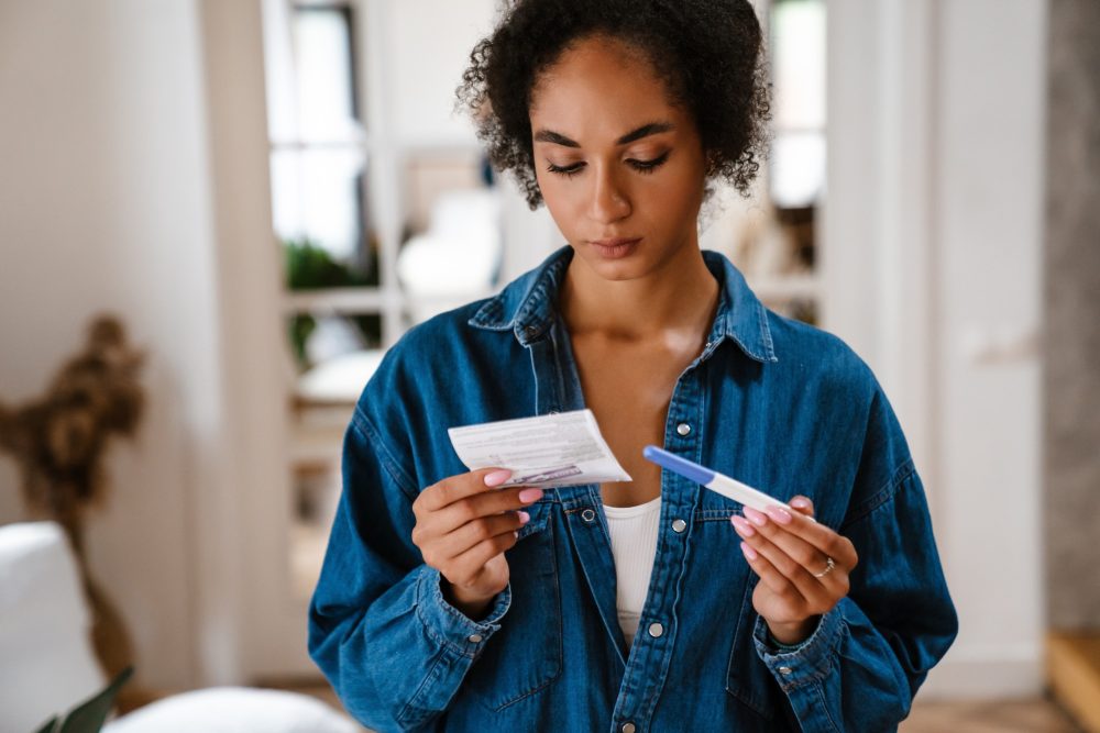 young woman looking concerned at a pregnancy test
